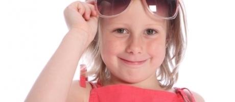 young girl holding up sunglasses